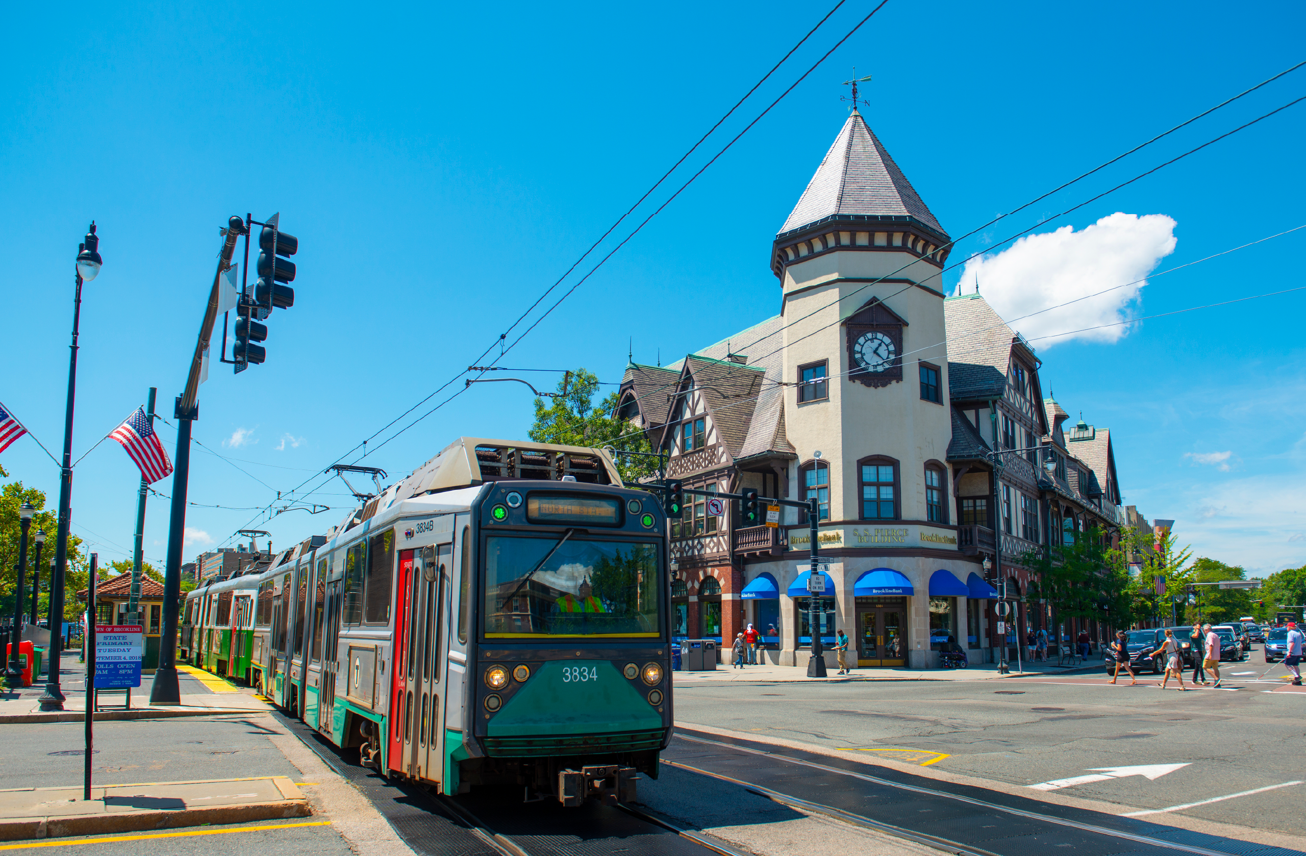 Street view of Coolidge Corner in Brookline, Massachusetts featuring local shops, restaurants, pedestrians, and historic architecture.